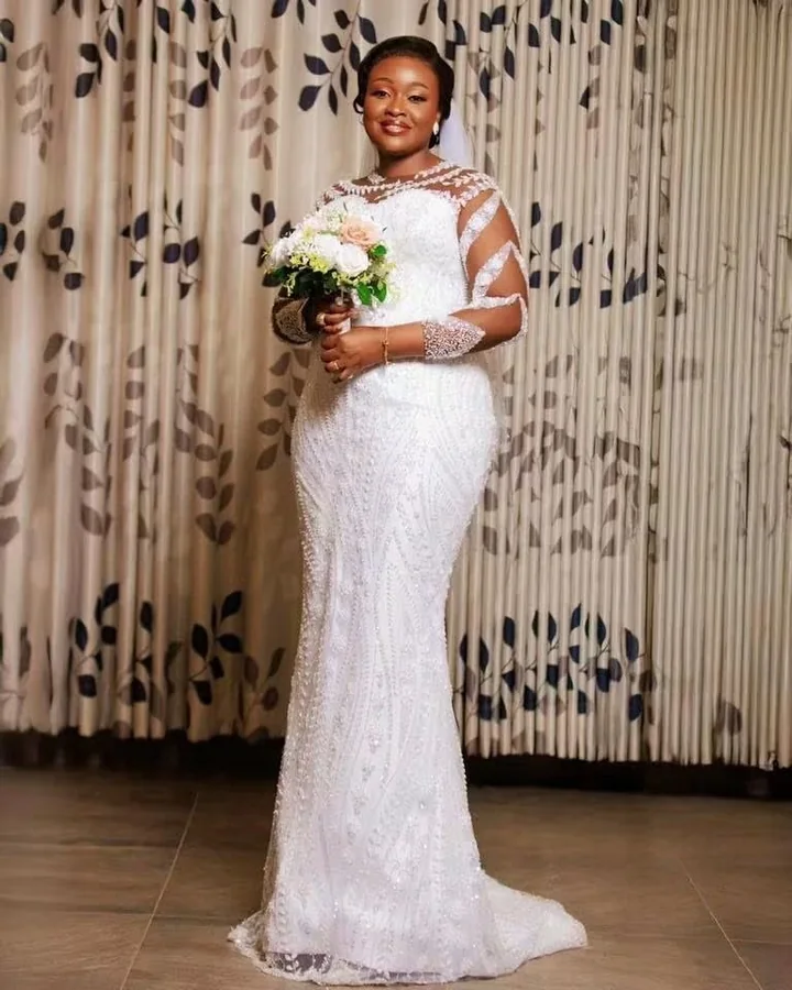 Mariée en robe sirène de dentelle blanche, bouquet de roses